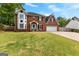 Traditional brick home featuring a lush green lawn, a welcoming light blue door, and a two-car garage at 317 Calgary Dr, Peachtree City, GA 30269