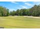 Scenic view of a meticulously maintained golf course with lush greenery, mature trees, and challenging sand traps at 317 Calgary Dr, Peachtree City, GA 30269