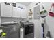 Modern laundry room with sleek, front-loading washer and dryer and ample storage cabinets at 317 Calgary Dr, Peachtree City, GA 30269