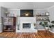 Bright living room features a white brick fireplace, hardwood floors, and stylish decor at 317 Calgary Dr, Peachtree City, GA 30269