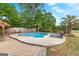 Backyard featuring a large in-ground pool with a brick surround, lounge chairs, and mature trees at 317 Calgary Dr, Peachtree City, GA 30269