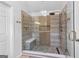 Modern shower featuring frameless glass enclosure, rainfall showerhead, bench, and mosaic tile flooring with wood look tile at 317 Calgary Dr, Peachtree City, GA 30269