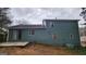 An exterior of the rear of the home with a concrete patio, dark siding, and trimmed lawn at 5128 Running Fox Trl, Norcross, GA 30071