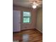 Simple bedroom featuring hardwood floors, a window, and a white door at 5128 Running Fox Trl, Norcross, GA 30071