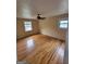 A bedroom showcasing gleaming hardwood floors, two windows, and a ceiling fan at 5128 Running Fox Trl, Norcross, GA 30071