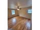 A bedroom showcasing gleaming hardwood floors, two windows, and a ceiling fan at 5128 Running Fox Trl, Norcross, GA 30071