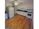 Spacious kitchen with white appliances, white cabinets, hardwood floors, and a ceiling fan at 5128 Running Fox Trl, Norcross, GA 30071