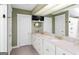 Bathroom featuring double sinks, white cabinetry, and decorative mirrors at 171 Westminster Ne Dr, Atlanta, GA 30309