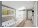 Luxurious bathroom with jacuzzi tub, skylight, walk-in shower, and tiled floors at 171 Westminster Ne Dr, Atlanta, GA 30309