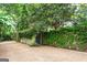 Gated driveway lined with lush greenery and vine-covered walls offering privacy at 171 Westminster Ne Dr, Atlanta, GA 30309