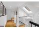 Bright hallway with hardwood floors, white trim, a skylight, and wrought iron railing at 171 Westminster Ne Dr, Atlanta, GA 30309