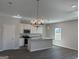 Open-concept kitchen and living area with stainless appliances and modern light fixtures at 5322 Tolar Rd # 27, South Fulton, GA 30213