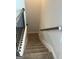 Carpeted stairway with stained wood handrail and black metal balusters leads to the lower level at 5322 Tolar Rd # 27, South Fulton, GA 30213