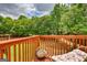 Relaxing backyard deck with green tree views and outdoor chair and chaise lounge at 2160 Dillard Xing, Tucker, GA 30084