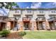 Backyard of townhomes with brick foundations, green grass, and wooden decks at 2160 Dillard Xing, Tucker, GA 30084