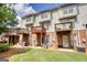 Backyard of townhomes with brick foundations, green grass, wooden decks and air conditioning units at 2160 Dillard Xing, Tucker, GA 30084