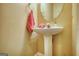 Cozy powder room features a pedestal sink with a mirror and a neutral color palette at 2160 Dillard Xing, Tucker, GA 30084