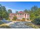 Well-maintained brick residence with a circular driveway and lush landscaping, set against a backdrop of mature trees at 7523 Kimberly Lynn Ct, Lithonia, GA 30058