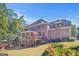 A multi-story brick home with a wooden deck, well-maintained lawn, and landscaped garden at 7523 Kimberly Lynn Ct, Lithonia, GA 30058