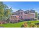 A multi-story brick home with a wooden deck, well-maintained lawn, and landscaped garden at 7523 Kimberly Lynn Ct, Lithonia, GA 30058