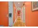 Spacious hallway with hardwood floors and vibrant orange walls leading to various rooms at 7523 Kimberly Lynn Ct, Lithonia, GA 30058