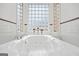 Close-up of luxurious jetted tub with glass block window at 7523 Kimberly Lynn Ct, Lithonia, GA 30058