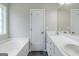 Well-lit bathroom featuring dual sinks, vanity, and a bathtub at 90 Heatherstone Way, Covington, GA 30016