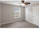 Neutral bedroom with carpeted floor, ceiling fan, and window view at 90 Heatherstone Way, Covington, GA 30016