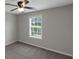 Bedroom featuring a large window, ceiling fan, and neutral carpet at 90 Heatherstone Way, Covington, GA 30016