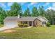 Traditional-style home featuring a manicured lawn, attached garage, and stone facade at 90 Heatherstone Way, Covington, GA 30016