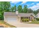 Lovely ranch-style home with an attached garage, stone detailing, and a curved driveway at 90 Heatherstone Way, Covington, GA 30016