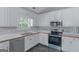 Modern kitchen featuring white cabinetry, stainless steel appliances, and a tile backsplash at 90 Heatherstone Way, Covington, GA 30016