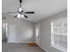 Open living area with a ceiling fan, neutral walls, and a view of the front door at 90 Heatherstone Way, Covington, GA 30016