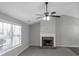 Bright living room featuring a brick fireplace, plush carpeting, and a large window at 90 Heatherstone Way, Covington, GA 30016