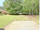 Spacious backyard featuring a gravel pad, partially fenced perimeter, and lush greenery at 15 Riverside Pkwy, Sharpsburg, GA 30277
