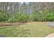 The expansive backyard showcases a lush lawn and beautiful mature trees at 15 Riverside Pkwy, Sharpsburg, GA 30277