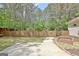 A fenced backyard has mature trees and a concrete patio for outdoor entertaining at 15 Riverside Pkwy, Sharpsburg, GA 30277