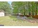 The backyard with lawn, storage building, and firepit area, offers versatile spaces for relaxation and outdoor activities at 15 Riverside Pkwy, Sharpsburg, GA 30277