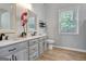 Bathroom boasts double sinks, decorative vanity, and wood-look flooring and natural light at 15 Riverside Pkwy, Sharpsburg, GA 30277