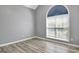 Bedroom featuring a large arched window with natural light and wood-look flooring at 15 Riverside Pkwy, Sharpsburg, GA 30277