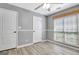 A bright bedroom with wood-look flooring has a ceiling fan and natural lighting at 15 Riverside Pkwy, Sharpsburg, GA 30277