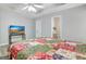 Bright bedroom features a quilt-covered bed, tray ceiling with fan and television set at 15 Riverside Pkwy, Sharpsburg, GA 30277