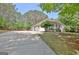 Long driveway leading to a cozy house with a well-kept lawn and a backdrop of mature trees at 15 Riverside Pkwy, Sharpsburg, GA 30277
