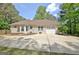 Home exterior featuring an attached garage, surrounded by mature trees and ample parking space at 15 Riverside Pkwy, Sharpsburg, GA 30277