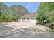 Side view of home with an attached garage and a spacious driveway, nestled among lush trees at 15 Riverside Pkwy, Sharpsburg, GA 30277