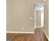 Beige hallway with hardwood flooring, offering entrance to a powder room at 15 Riverside Pkwy, Sharpsburg, GA 30277