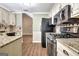 Kitchen with white cabinets, black appliances, tile backsplash, and wood floors at 15 Riverside Pkwy, Sharpsburg, GA 30277
