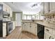 Kitchen with sink, white cabinets, dark appliances, granite counters, and wood floors at 15 Riverside Pkwy, Sharpsburg, GA 30277