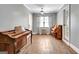 Two pianos in large living area featuring hardwood floors, ceiling fan, and natural light from window at 15 Riverside Pkwy, Sharpsburg, GA 30277
