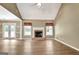 Bright living room with a cozy fireplace, hardwood floors, and a view of the outdoor patio through French doors at 15 Riverside Pkwy, Sharpsburg, GA 30277